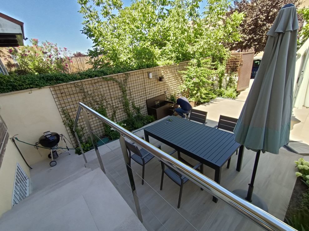 Immagine di un piccolo patio o portico minimalista davanti casa con fontane, piastrelle e nessuna copertura