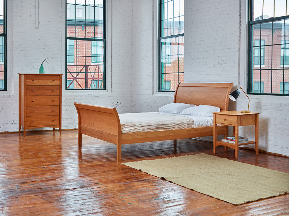 Inspiration for a mid-sized scandinavian loft-style bedroom in Portland Maine with white walls, dark hardwood floors and brown floor.