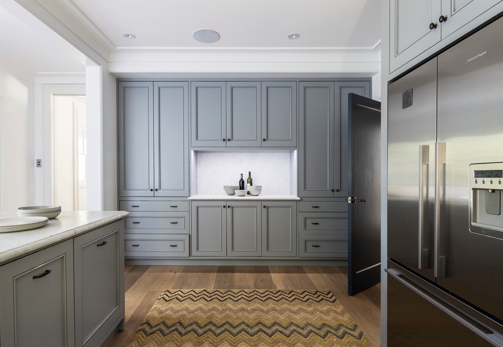 This is an example of a large transitional l-shaped eat-in kitchen in Sydney with an undermount sink, recessed-panel cabinets, grey cabinets, marble benchtops, grey splashback, stone slab splashback, stainless steel appliances, light hardwood floors and a peninsula.