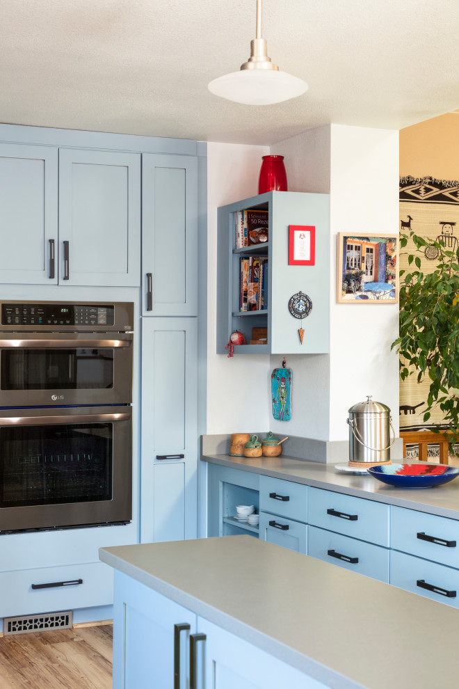 Immagine di un'ampia cucina moderna con lavello sottopiano, ante con riquadro incassato, ante blu, top in quarzo composito, elettrodomestici neri, pavimento in vinile, pavimento beige e top grigio