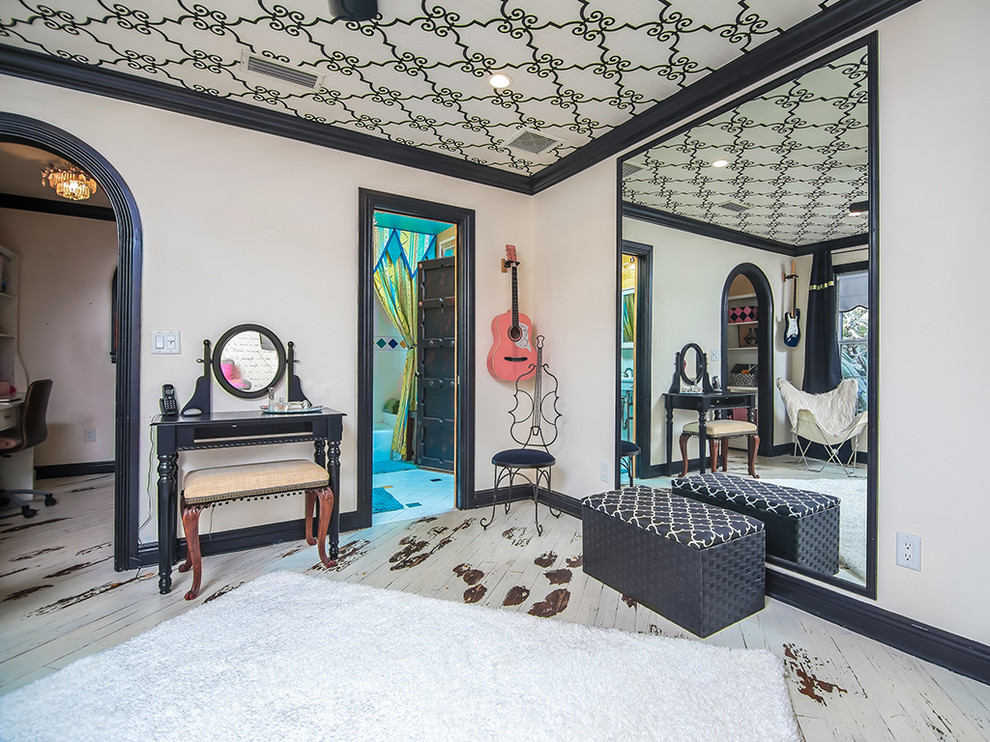 Inspiration for a mid-sized eclectic bedroom in Miami with white walls and painted wood floors.