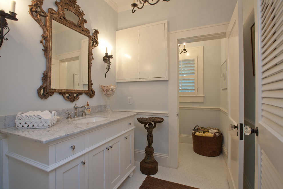 This is an example of a mediterranean bathroom in Tampa with an undermount sink, shaker cabinets, white cabinets and white tile.
