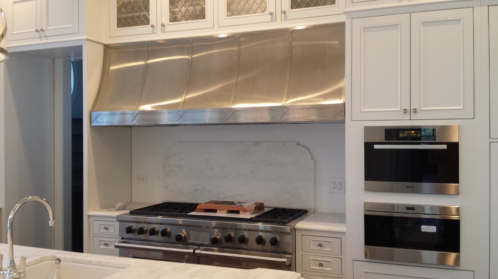 Mid-sized transitional l-shaped separate kitchen in Chicago with an undermount sink, beaded inset cabinets, white cabinets, quartz benchtops, white splashback, marble splashback, stainless steel appliances, medium hardwood floors, with island and brown floor.