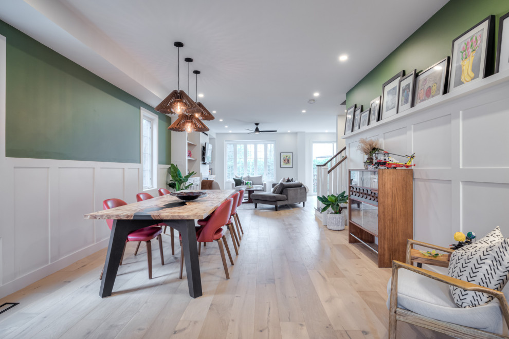 Inspiration pour une petite salle à manger ouverte sur la cuisine nordique avec un mur vert, parquet clair, une cheminée standard, un manteau de cheminée en bois, un sol beige et boiseries.