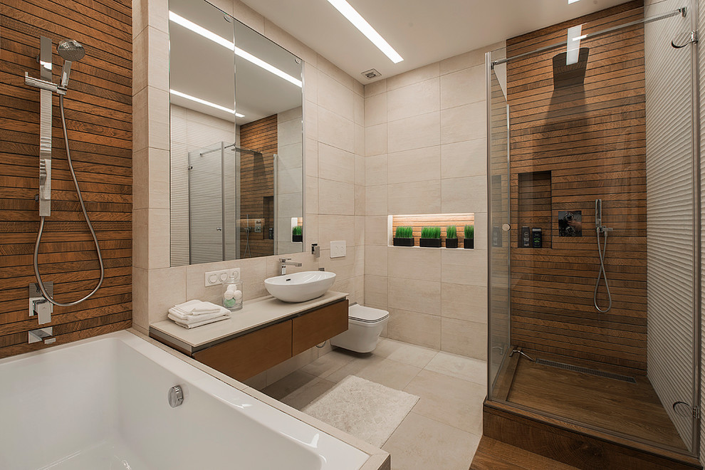 This is an example of a mid-sized contemporary master bathroom in Moscow with flat-panel cabinets, medium wood cabinets, an undermount tub, a wall-mount toilet, beige tile, porcelain tile, beige walls, porcelain floors, solid surface benchtops, beige floor, a hinged shower door, a corner shower and a vessel sink.