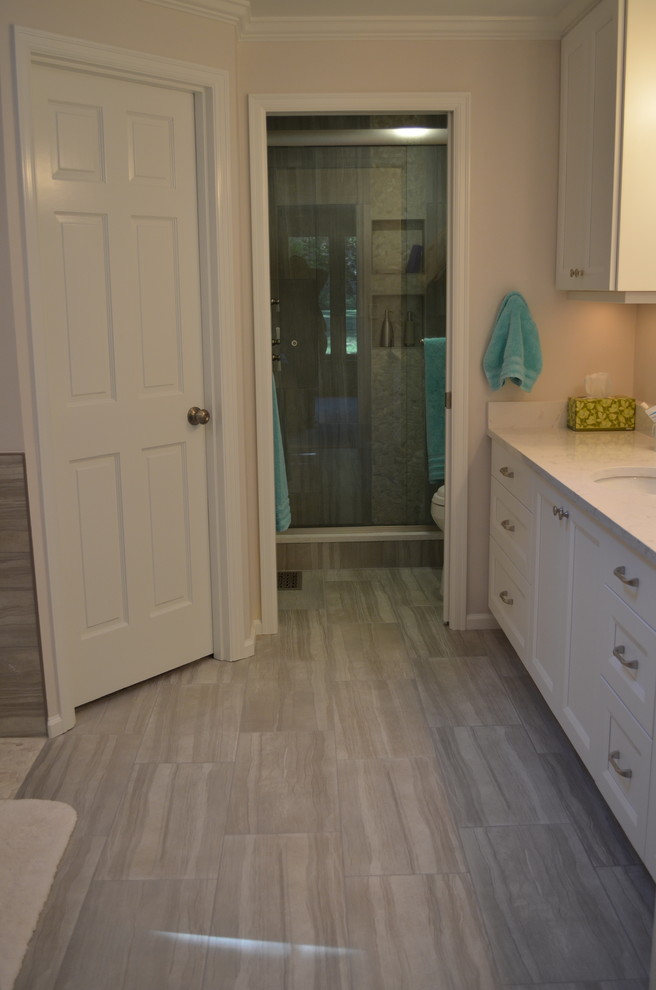 Large transitional master bathroom in Seattle with an undermount sink, shaker cabinets, white cabinets, engineered quartz benchtops, a freestanding tub, an alcove shower, a one-piece toilet, gray tile, porcelain tile, grey walls and porcelain floors.