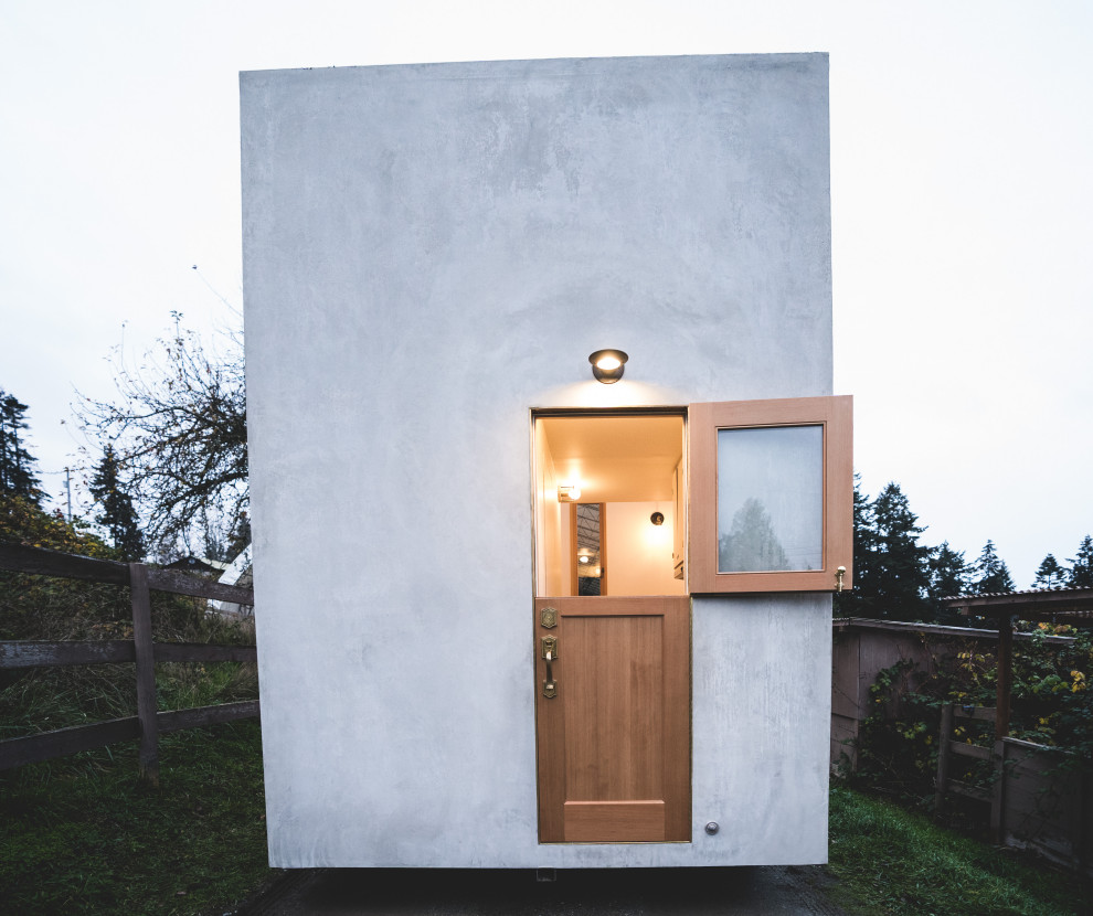 Photo of a small contemporary one-storey concrete grey exterior in Vancouver with a flat roof and a white roof.