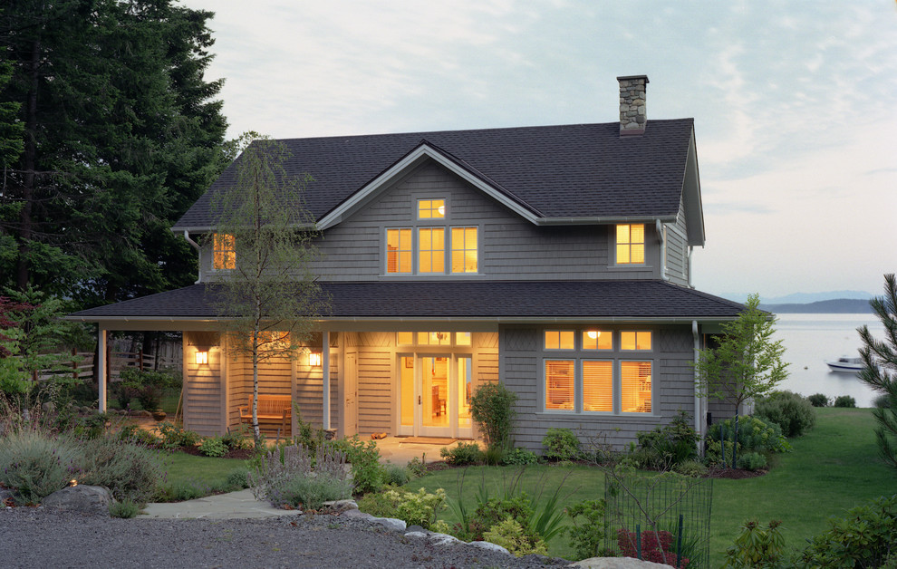 Photo of a mid-sized beach style two-storey grey exterior in Seattle with wood siding and a gable roof.