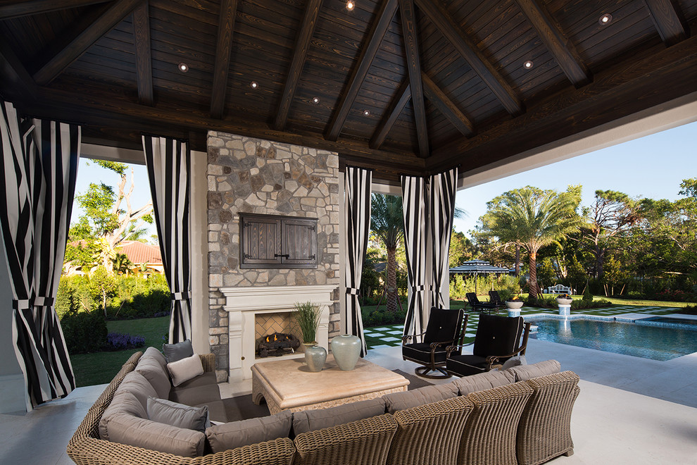 Design ideas for a traditional backyard patio in Miami with with fireplace.