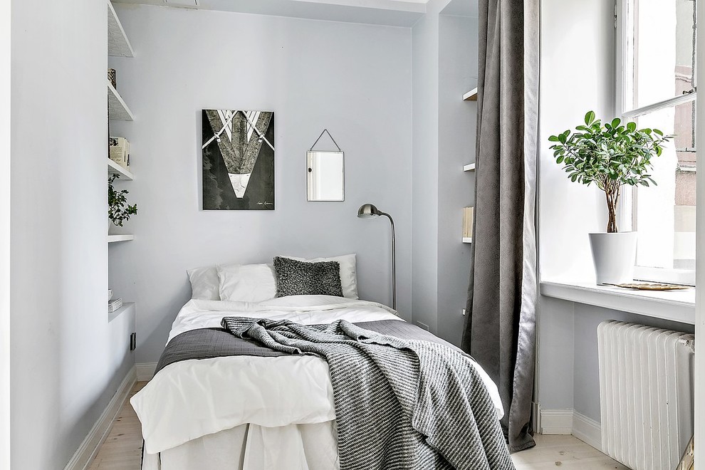 Photo of a scandinavian bedroom in Stockholm with grey walls, light hardwood floors, beige floor and no fireplace.