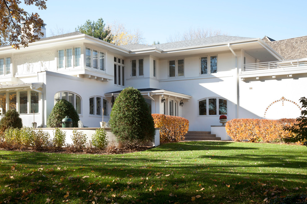 This is an example of a traditional two-storey stucco white exterior in Minneapolis with a hip roof.