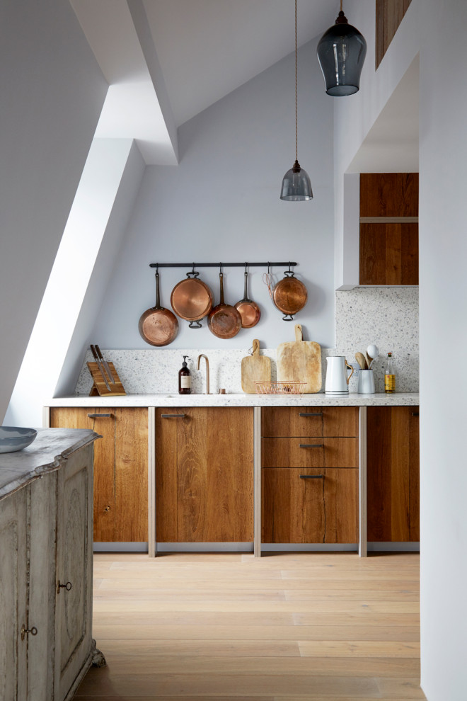 Inspiration for a large scandinavian galley open plan kitchen in London with a drop-in sink, recessed-panel cabinets, medium wood cabinets, terrazzo benchtops, black appliances and no island.
