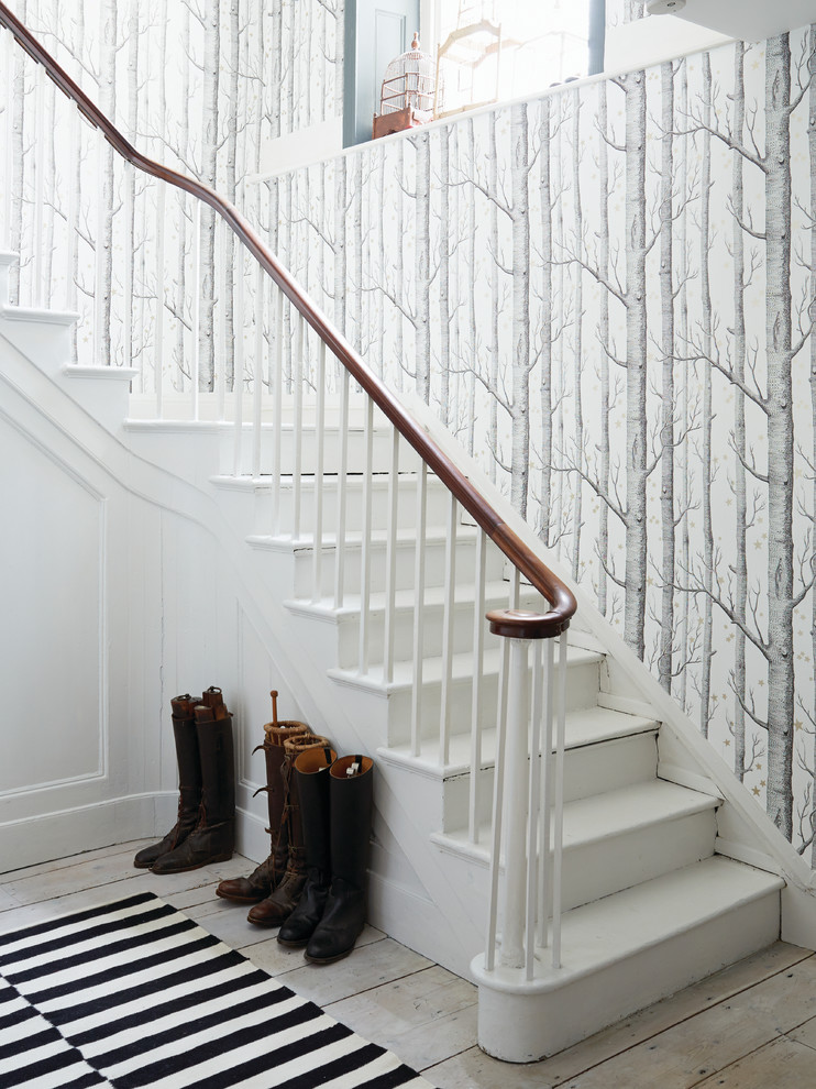 This is an example of a scandinavian painted wood l-shaped staircase in Sussex with painted wood risers.
