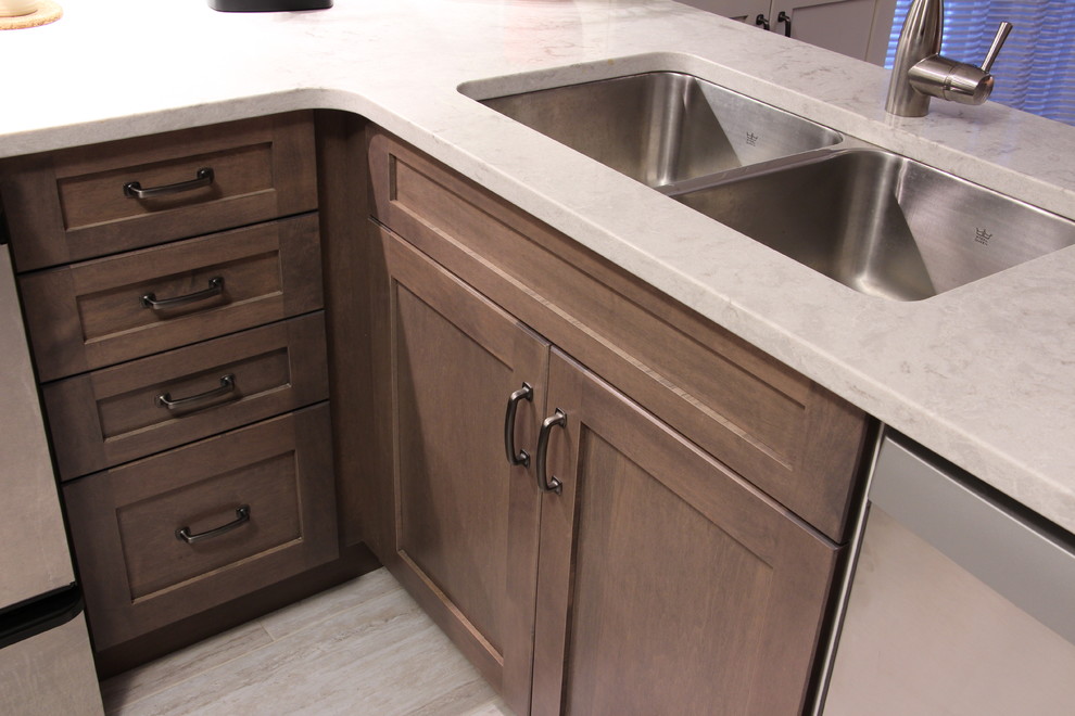 Eat-in kitchen - mid-sized transitional u-shaped ceramic tile and beige floor eat-in kitchen idea in Toronto with a double-bowl sink, shaker cabinets, gray cabinets, solid surface countertops, gray backsplash, glass sheet backsplash, stainless steel appliances and no island