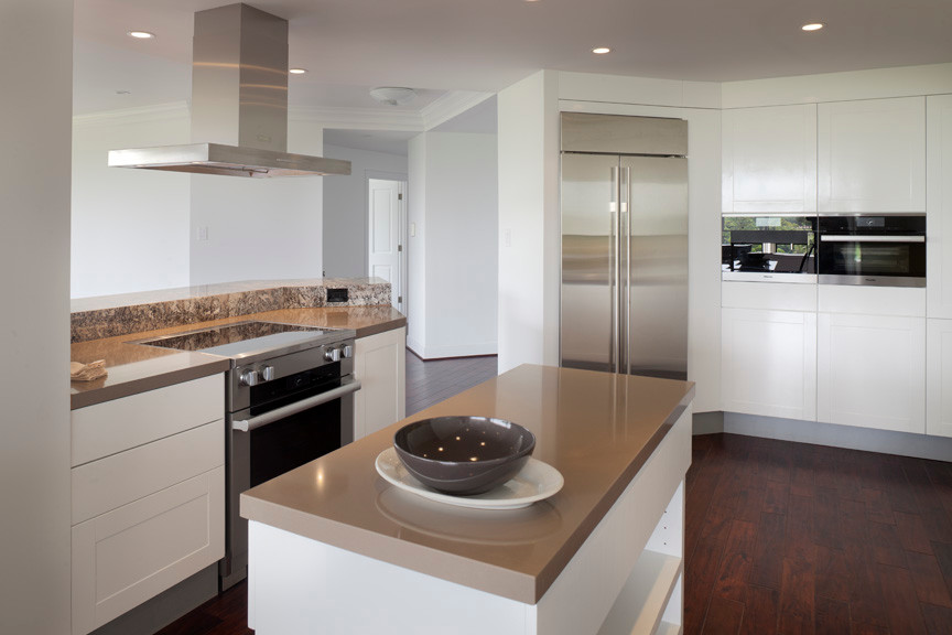 Eat-in kitchen - mid-sized modern galley medium tone wood floor eat-in kitchen idea in Houston with an undermount sink, flat-panel cabinets, white cabinets, solid surface countertops, brown backsplash, stone slab backsplash, stainless steel appliances and an island