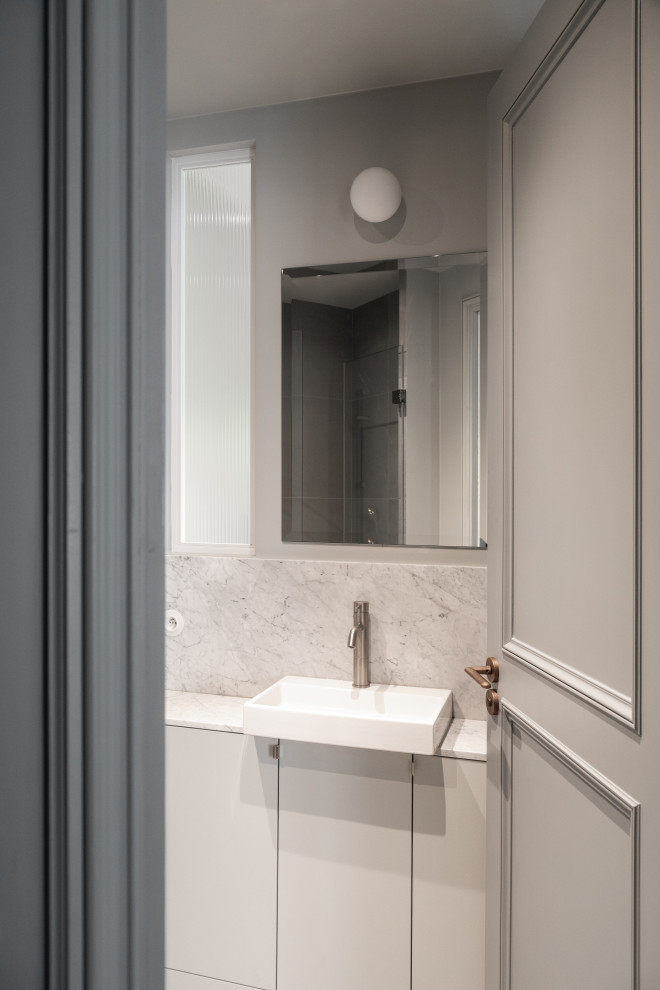 Medium sized contemporary grey and white bathroom in Paris with beaded cabinets, grey cabinets, an alcove shower, a wall mounted toilet, white tiles, ceramic tiles, grey walls, ceramic flooring, a submerged sink, tiled worktops, grey floors, white worktops, a wall niche and a single sink.