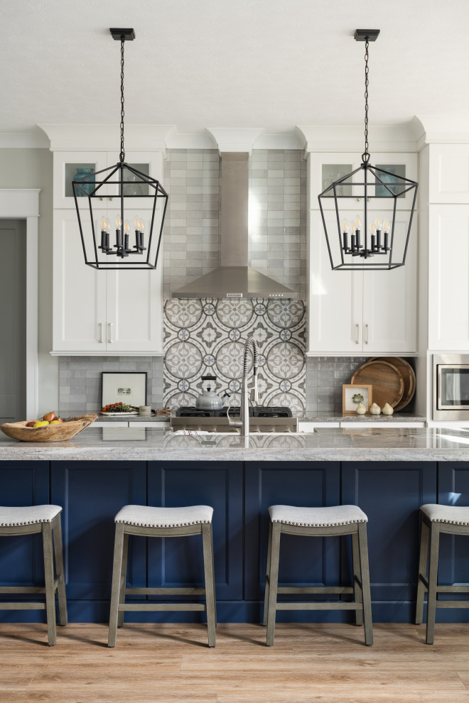 Inspiration för ett mellanstort funkis kök, med en undermonterad diskho, luckor med glaspanel, blå skåp, granitbänkskiva, vitt stänkskydd, rostfria vitvaror, mellanmörkt trägolv och en köksö