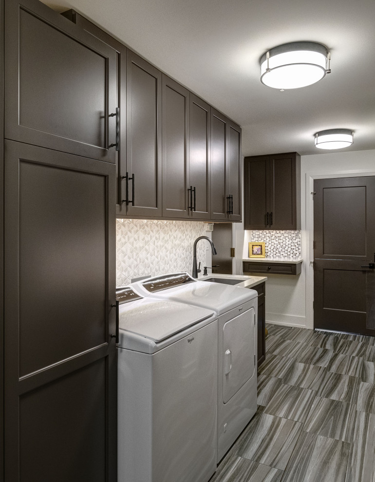Inspiration for a mid-sized transitional single-wall dedicated laundry room in Chicago with an undermount sink, shaker cabinets, brown cabinets, quartz benchtops, multi-coloured splashback, multi-coloured walls, a side-by-side washer and dryer, multi-coloured floor and multi-coloured benchtop.