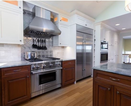 Inspiration for an expansive traditional l-shaped eat-in kitchen in Providence with a double-bowl sink, beaded inset cabinets, beige cabinets, granite benchtops, beige splashback, marble splashback, stainless steel appliances, bamboo floors, multiple islands and brown floor.