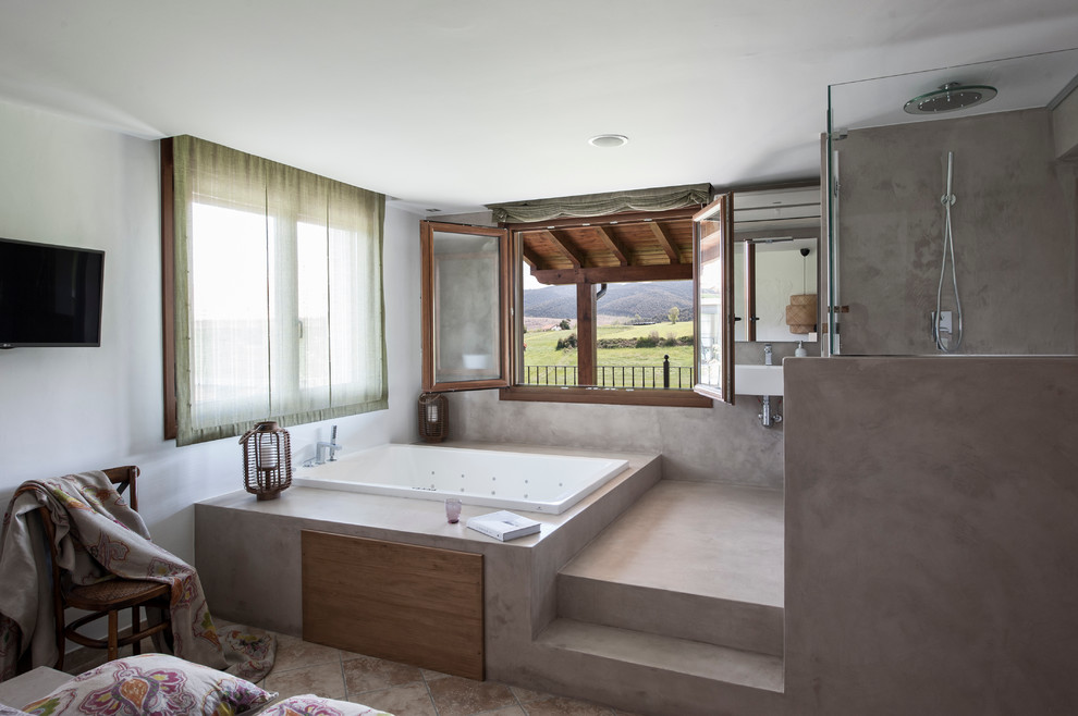 This is an example of a mid-sized mediterranean master bathroom in Other with a hot tub, an alcove shower, multi-coloured walls and concrete floors.