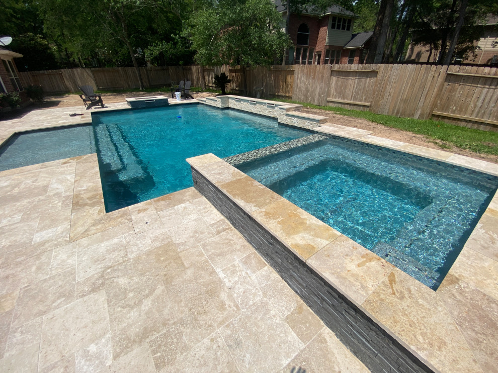 Immagine di una grande piscina monocorsia moderna personalizzata dietro casa con una vasca idromassaggio e pavimentazioni in pietra naturale