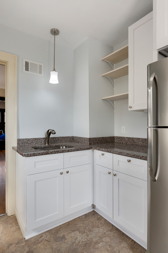 This is an example of a small contemporary separate kitchen in Minneapolis with an undermount sink, shaker cabinets, white cabinets, granite benchtops, stainless steel appliances, laminate floors and beige floor.