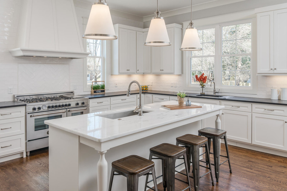 Design ideas for an expansive transitional kitchen in Nashville with a single-bowl sink, shaker cabinets, white cabinets, granite benchtops, white splashback, stainless steel appliances, dark hardwood floors, with island and brown floor.