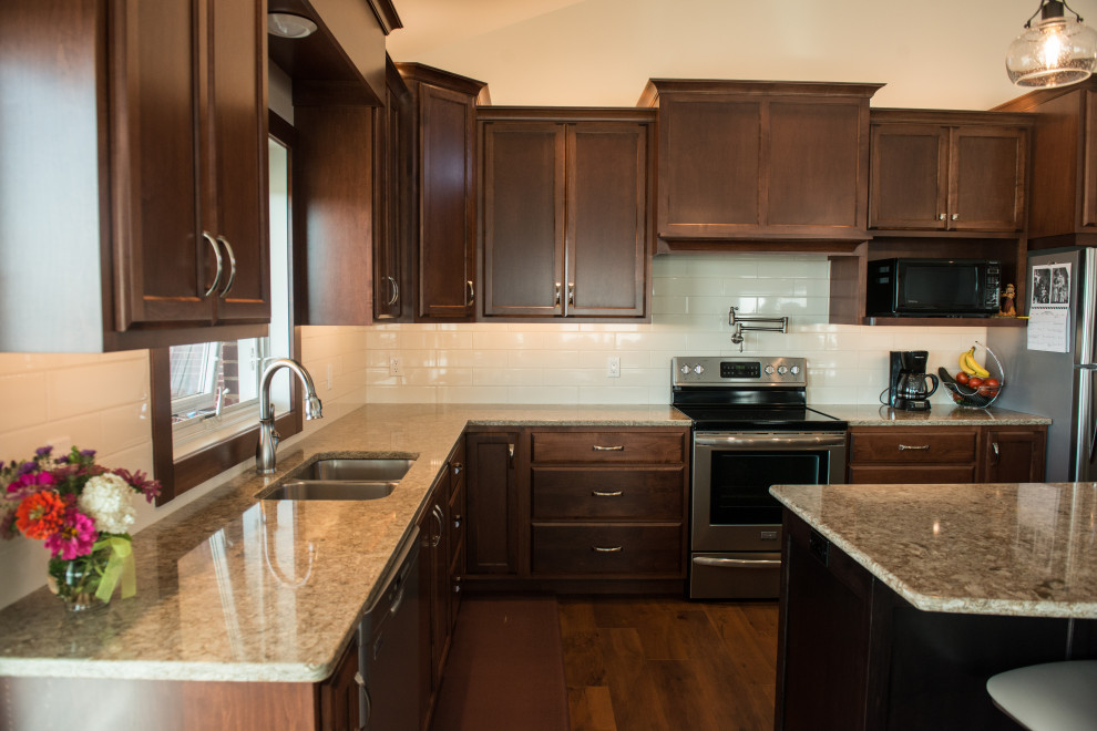 Inspiration for a large transitional l-shaped medium tone wood floor open concept kitchen remodel with an undermount sink, flat-panel cabinets, medium tone wood cabinets, quartz countertops, white backsplash, ceramic backsplash, stainless steel appliances, an island and multicolored countertops