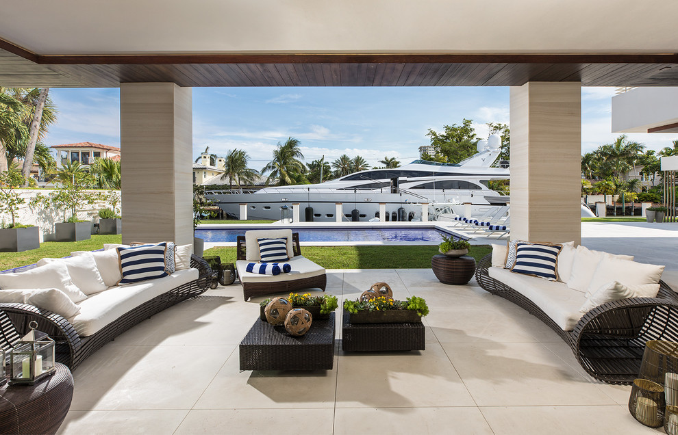 Expansive beach style backyard verandah in Miami with tile, a roof extension and a container garden.