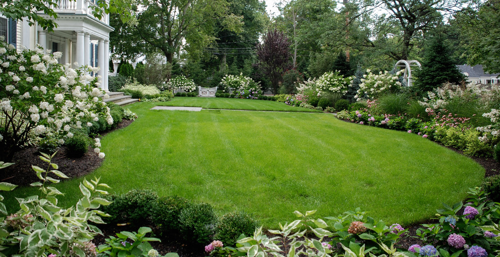 Design ideas for a mid-sized traditional front yard full sun formal garden in Boston with natural stone pavers.