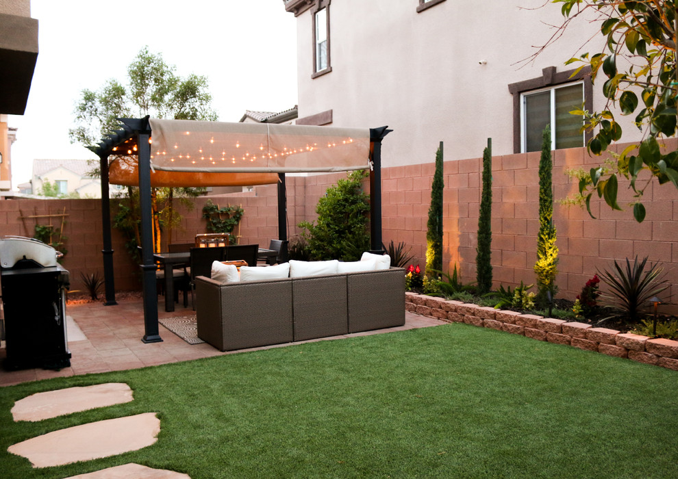 Small transitional backyard patio in Las Vegas with concrete pavers and a pergola.