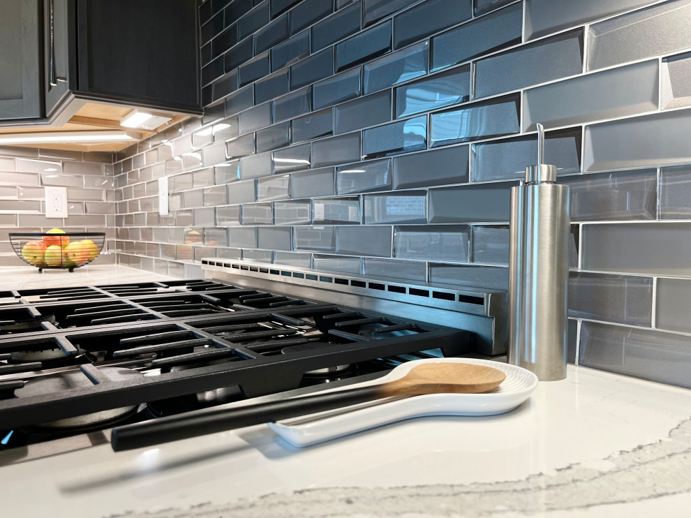 Eat-in kitchen - mid-sized transitional l-shaped dark wood floor and brown floor eat-in kitchen idea with an undermount sink, gray cabinets, quartz countertops, glass tile backsplash, stainless steel appliances, an island, white backsplash and beige countertops