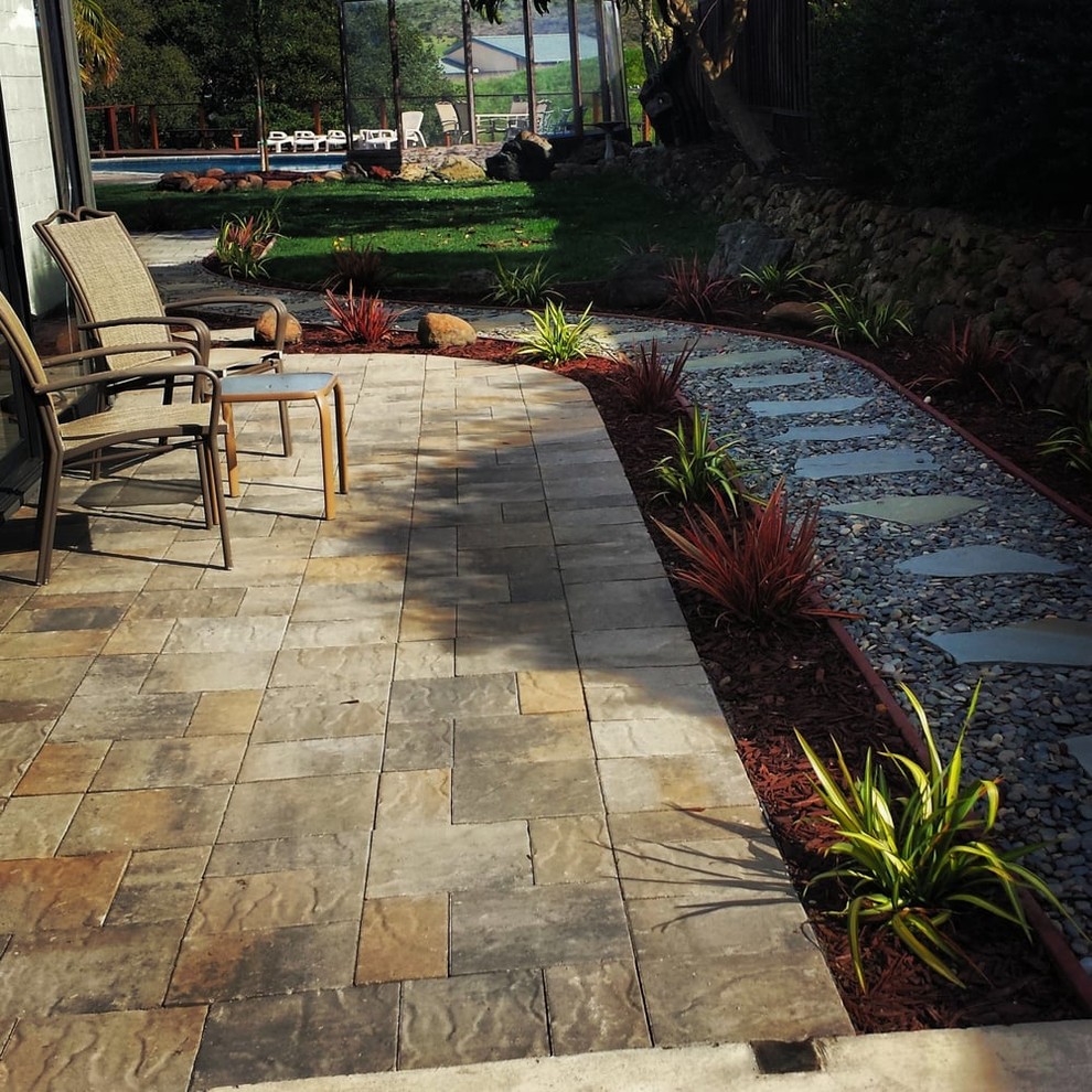 Photo of a mid-sized traditional side yard patio in San Francisco with natural stone pavers and no cover.