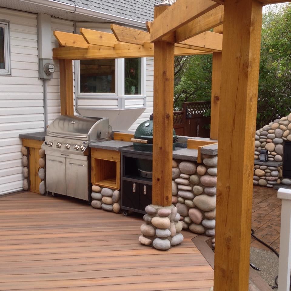 Large eclectic backyard outdoor kitchen deck photo in Calgary with a pergola