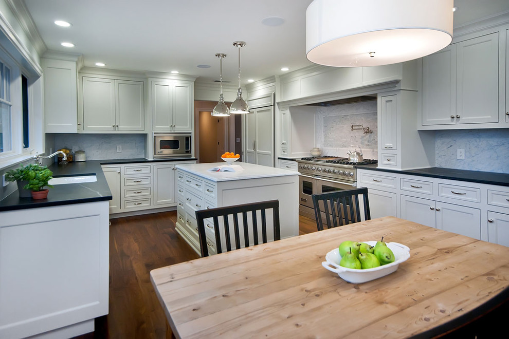 Photo of a traditional u-shaped eat-in kitchen in San Francisco with recessed-panel cabinets, white cabinets, grey splashback and stainless steel appliances.