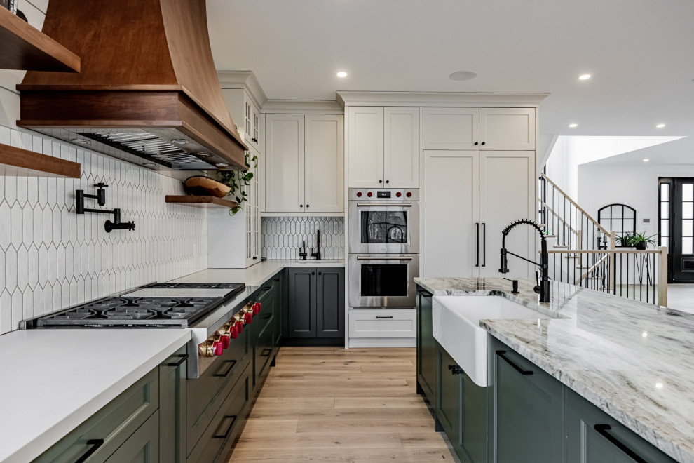 Small transitional u-shaped kitchen pantry in DC Metro with a single-bowl sink, green cabinets, quartz benchtops, white splashback, ceramic splashback, stainless steel appliances, bamboo floors, with island, brown floor and white benchtop.