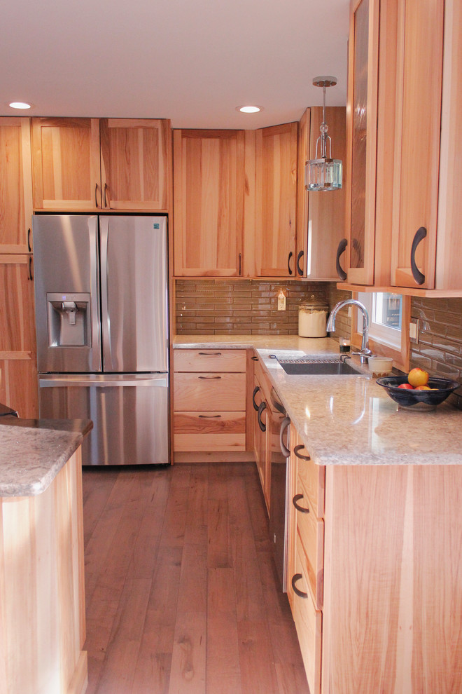 Example of a large transitional l-shaped light wood floor kitchen design with an undermount sink, shaker cabinets, light wood cabinets, quartzite countertops, brown backsplash, stainless steel appliances and an island