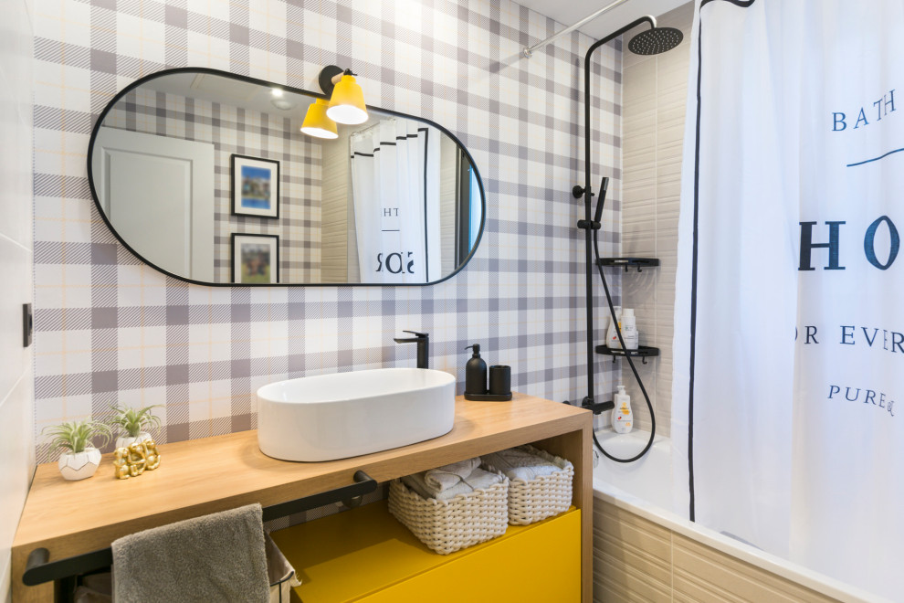 Пример оригинального дизайна: маленькая детская ванная комната в скандинавском стиле с плоскими фасадами, желтыми фасадами, ванной в нише, унитазом-моноблоком, разноцветной плиткой, серыми стенами, полом из керамической плитки, настольной раковиной, столешницей из дерева, бежевым полом, шторкой для ванной, коричневой столешницей, окном, тумбой под одну раковину, встроенной тумбой и обоями на стенах для на участке и в саду