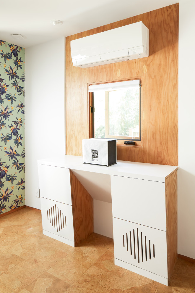 Cette photo montre un petit bureau tendance en bois de type studio avec un mur blanc, un sol en liège, aucune cheminée, un bureau intégré, un sol marron et poutres apparentes.
