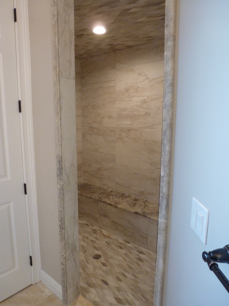 Mid-sized transitional master bathroom in Tampa with a drop-in tub, an alcove shower, a two-piece toilet, beige tile, limestone, grey walls, travertine floors, an undermount sink, beige floor and a hinged shower door.