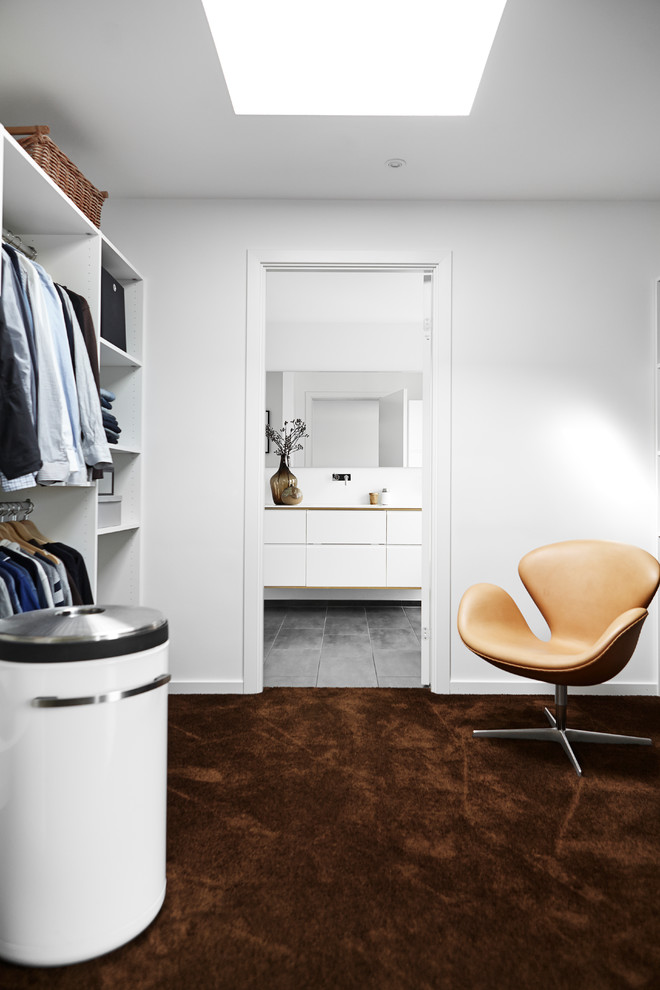 Design ideas for a large modern walk-in wardrobe in Aarhus with carpet and brown floor.