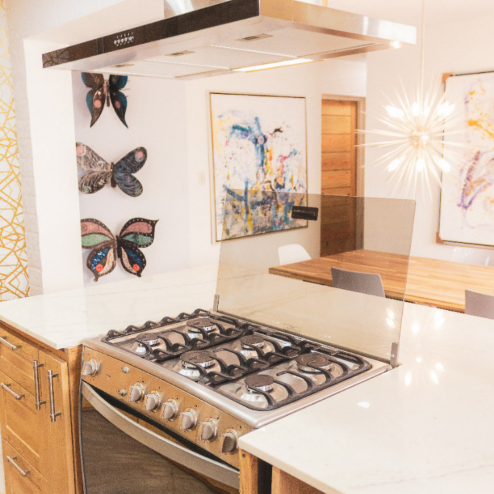 Mountain style brown floor eat-in kitchen photo with brown cabinets, quartzite countertops, white backsplash, subway tile backsplash, stainless steel appliances and white countertops