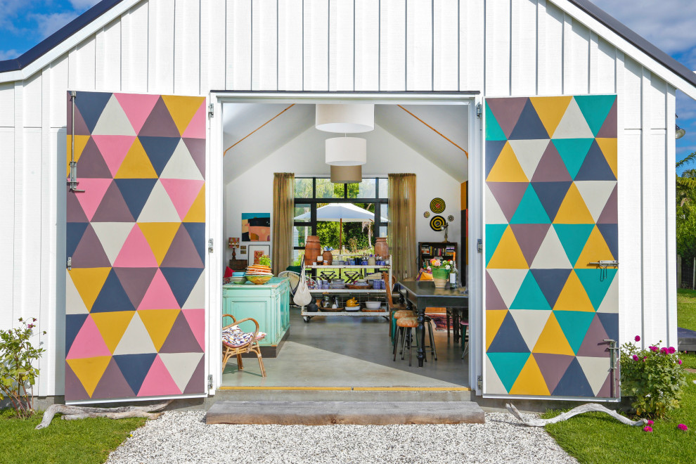 This is an example of an eclectic entryway in Auckland with a dutch front door.