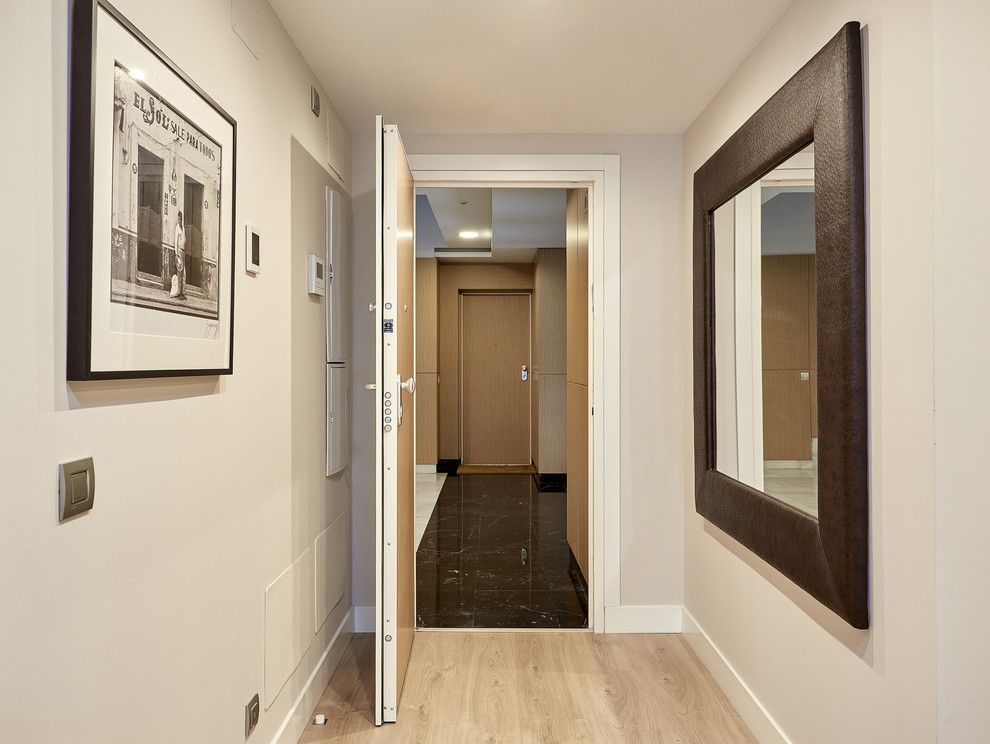 Imagen de entrada clásica renovada de tamaño medio con paredes grises, suelo de madera clara y suelo beige