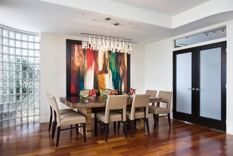 Photo of a mid-sized eclectic separate dining room in New York with white walls and bamboo floors.