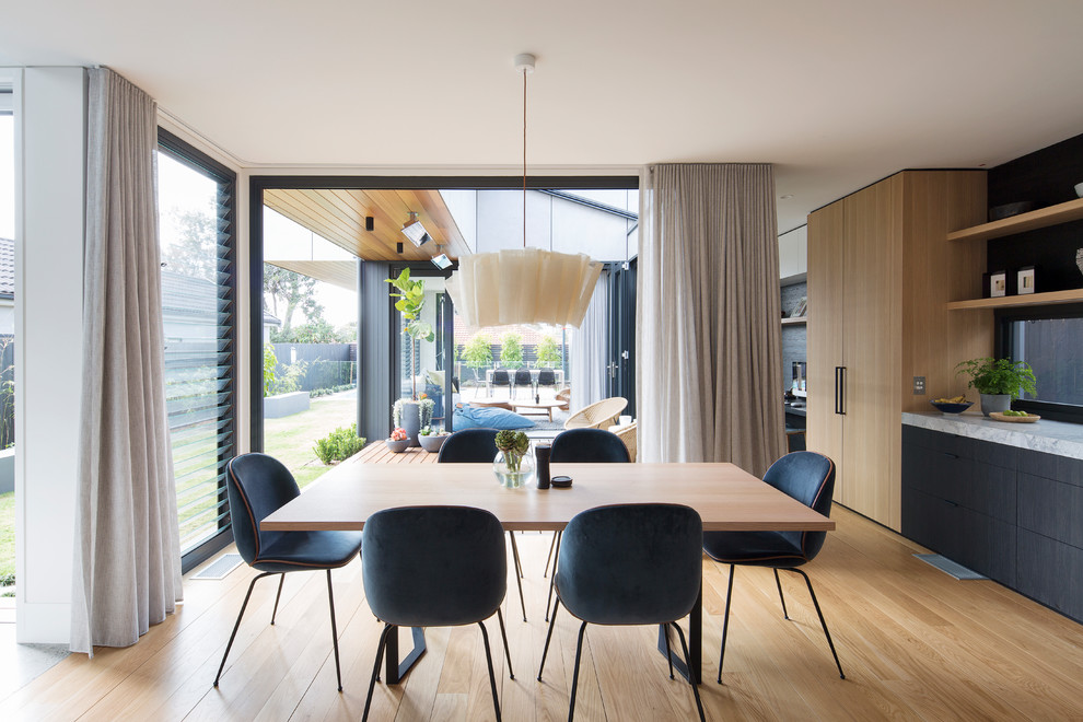 Design ideas for a mid-sized contemporary open plan dining in Sydney with light hardwood floors and beige floor.