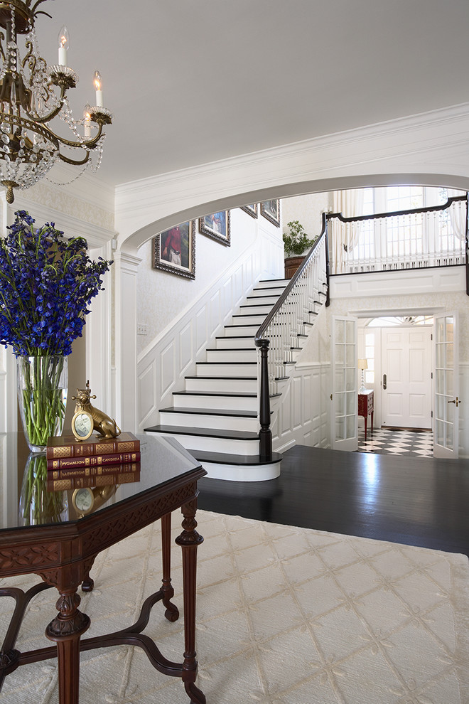 Inspiration for an expansive traditional foyer in Minneapolis with white walls, a single front door, a white front door, dark hardwood floors and multi-coloured floor.
