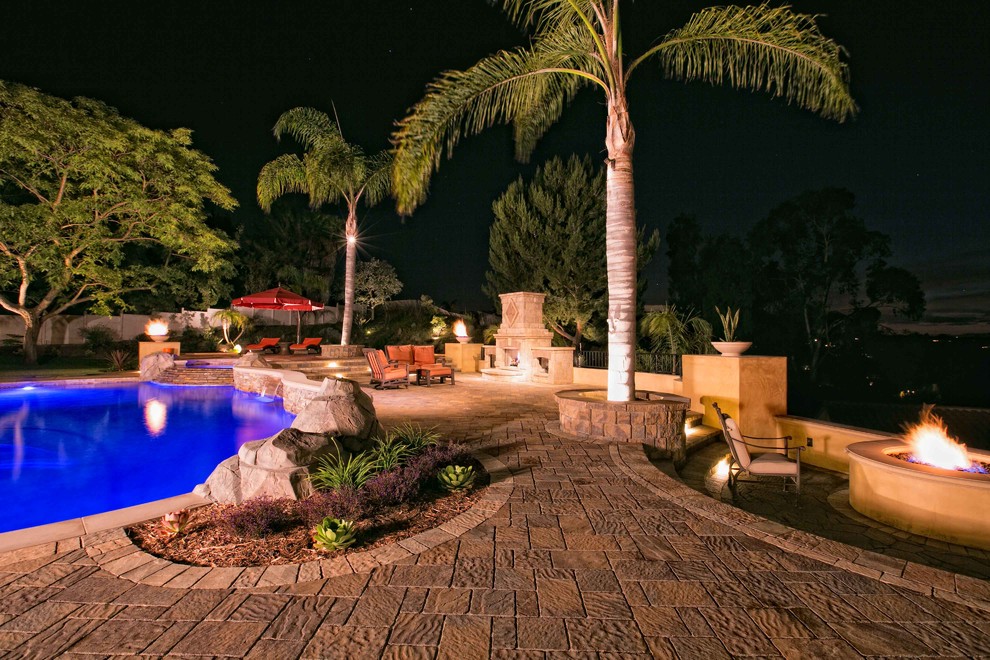 This is an example of an expansive backyard custom-shaped natural pool in San Diego with concrete pavers.