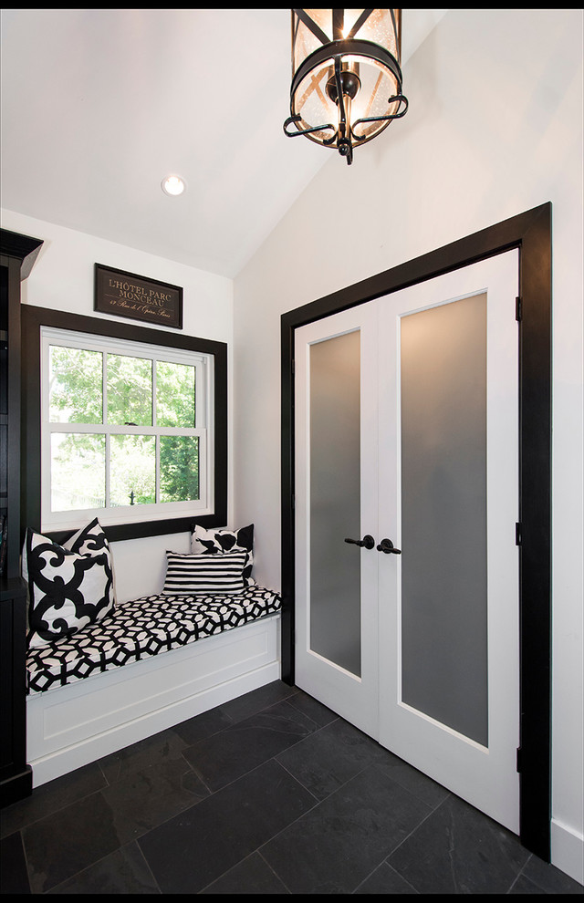 Example of a mid-sized transitional porcelain tile and black floor mudroom design with white walls