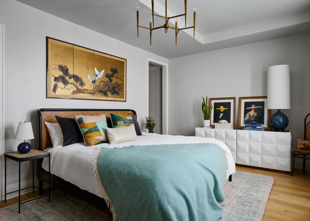 Example of a trendy medium tone wood floor, brown floor and tray ceiling bedroom design in Chicago with gray walls